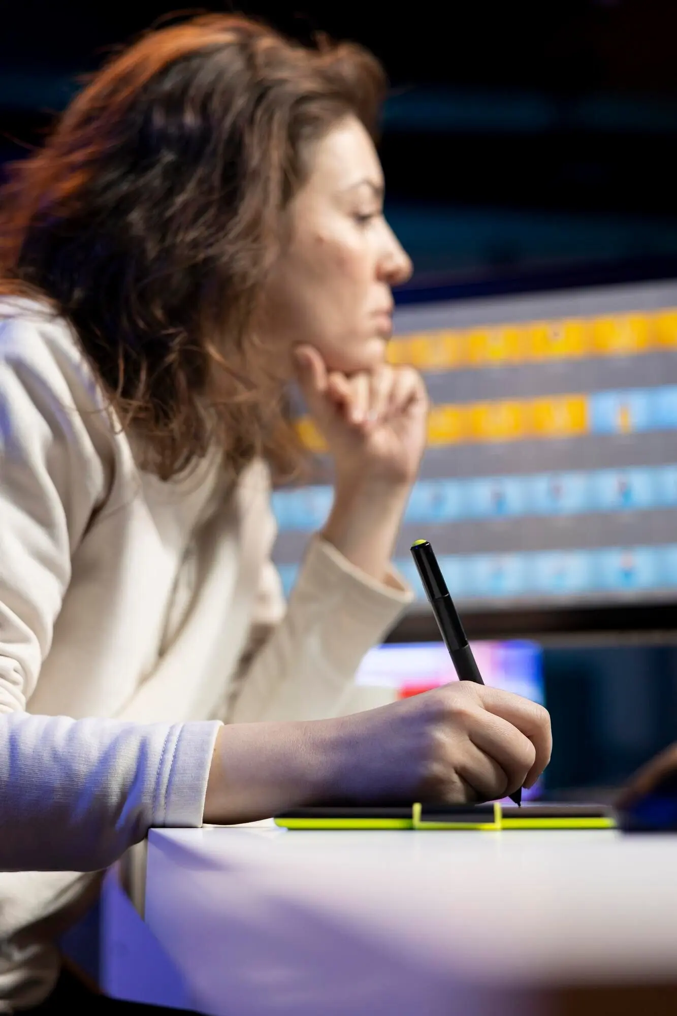 Крупный план: редактор фотографий выполняет цветокоррекцию снимков с помощью графического планшета.